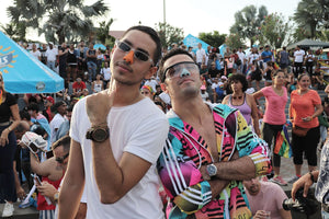 Two handsome young men at a campground festival wearing colorful Noz sunscreen with zinc oxide